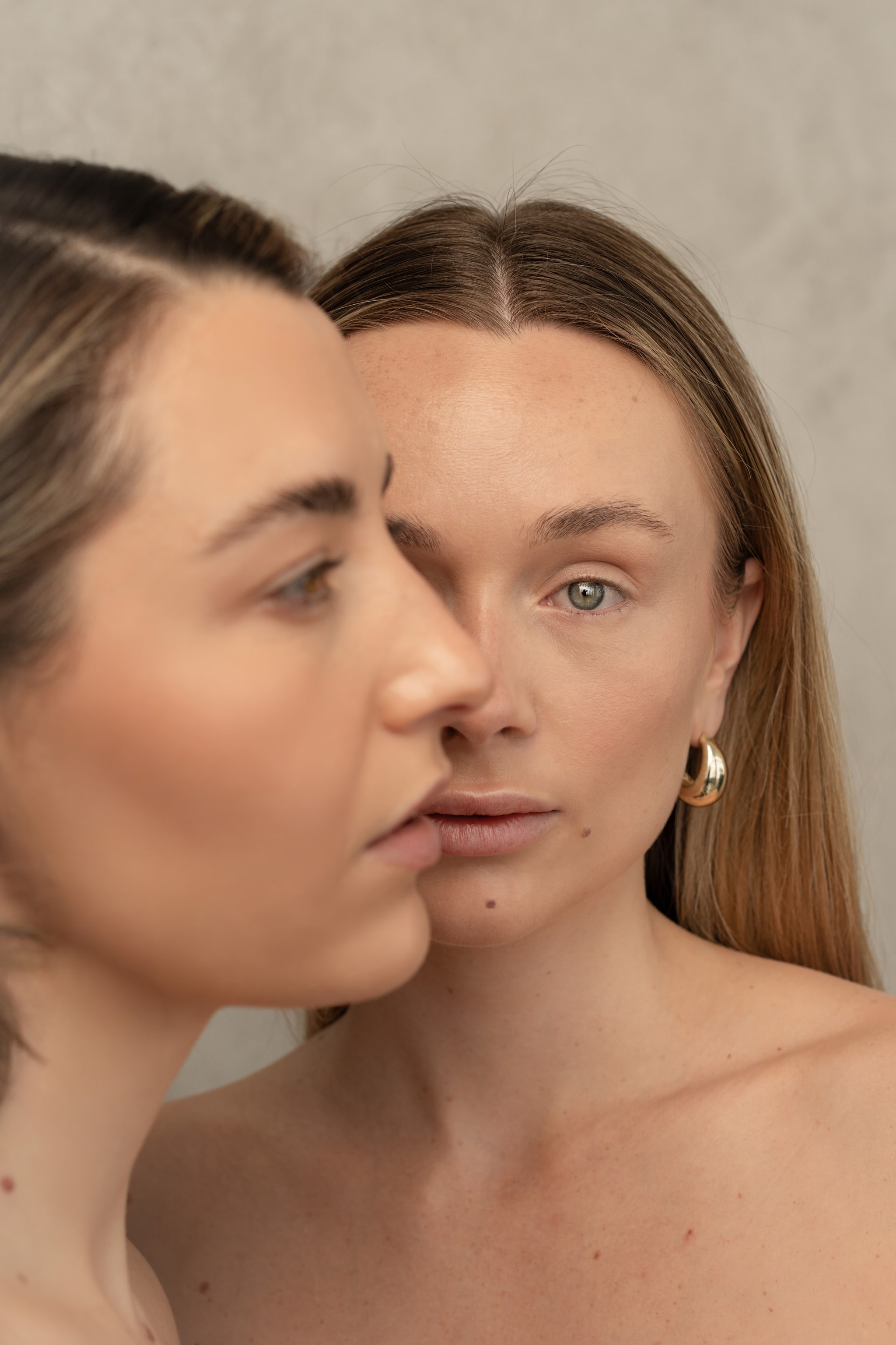 Aesthetics by Maddison. two models cheek-to-cheek, gold earrings