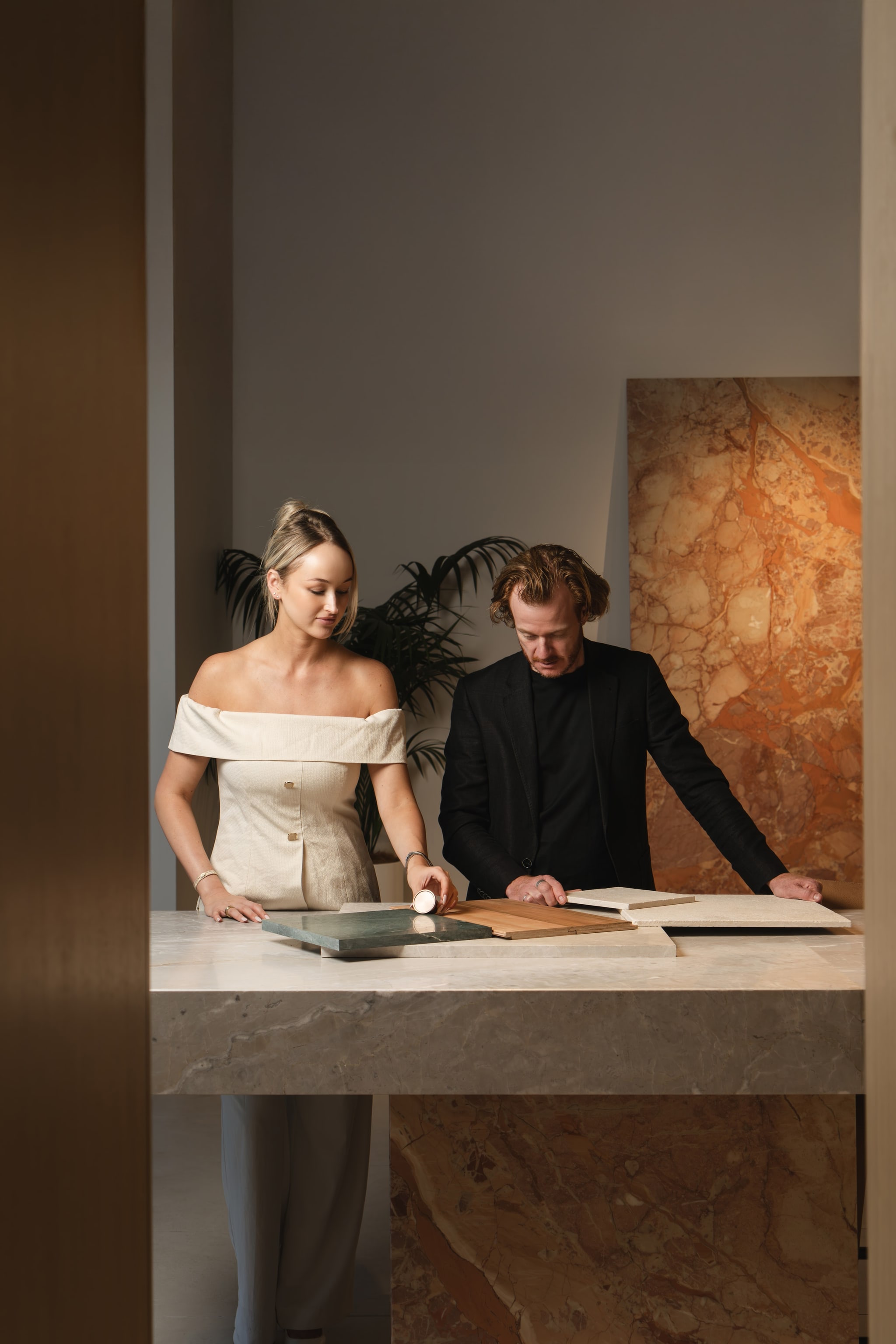 Two team members reviewing material samples on a marble plinth. Spyre Group
