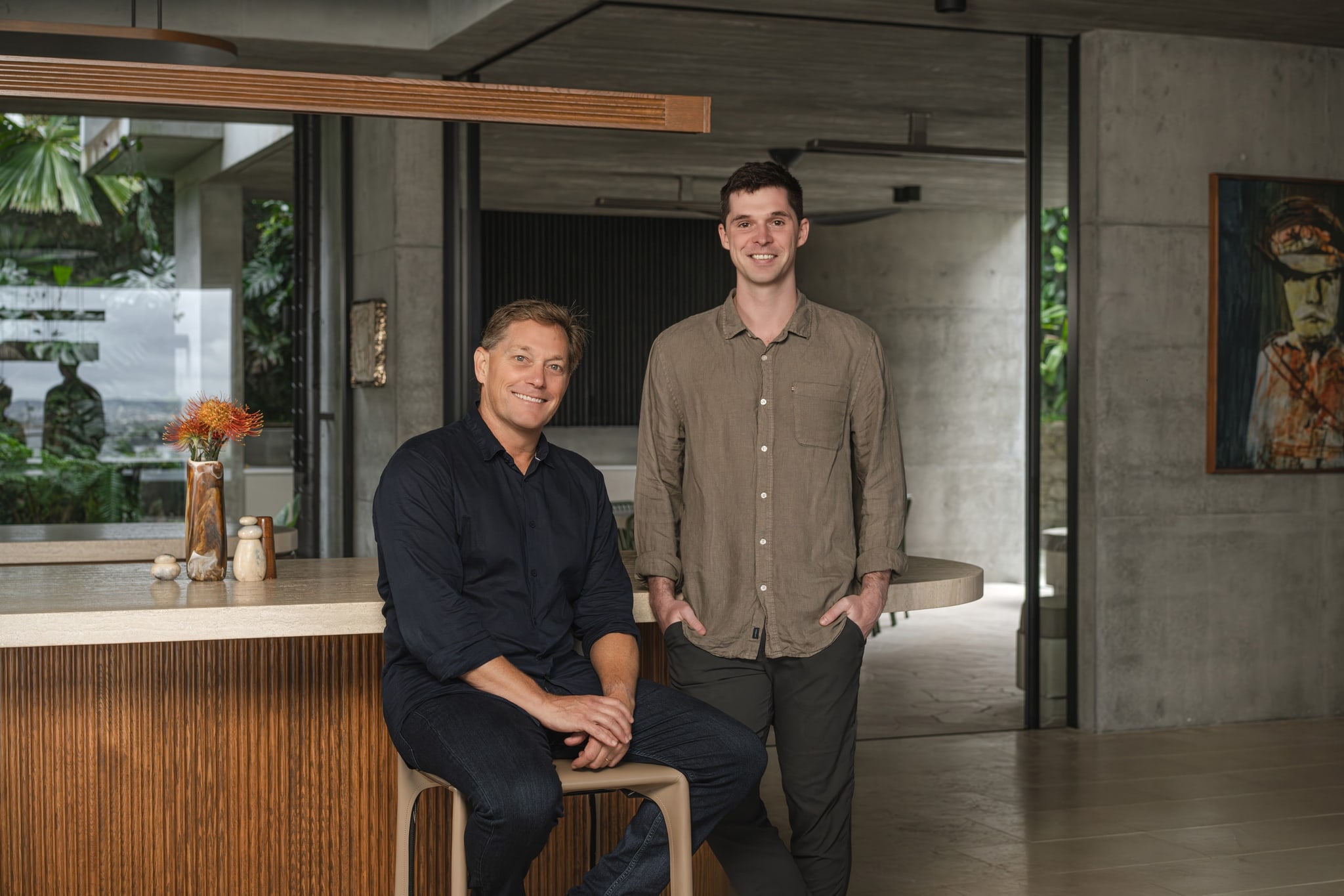 Two founders at a kitchen island in a concrete-and-timber home. TH7