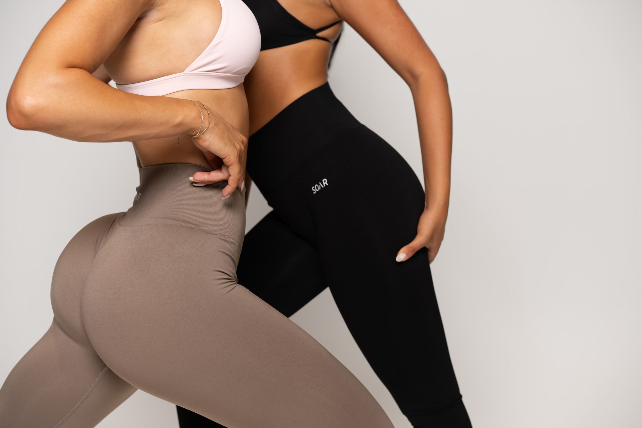 Soar Fitness campaign frame. Single subject in training apparel against a warm cream backdrop.